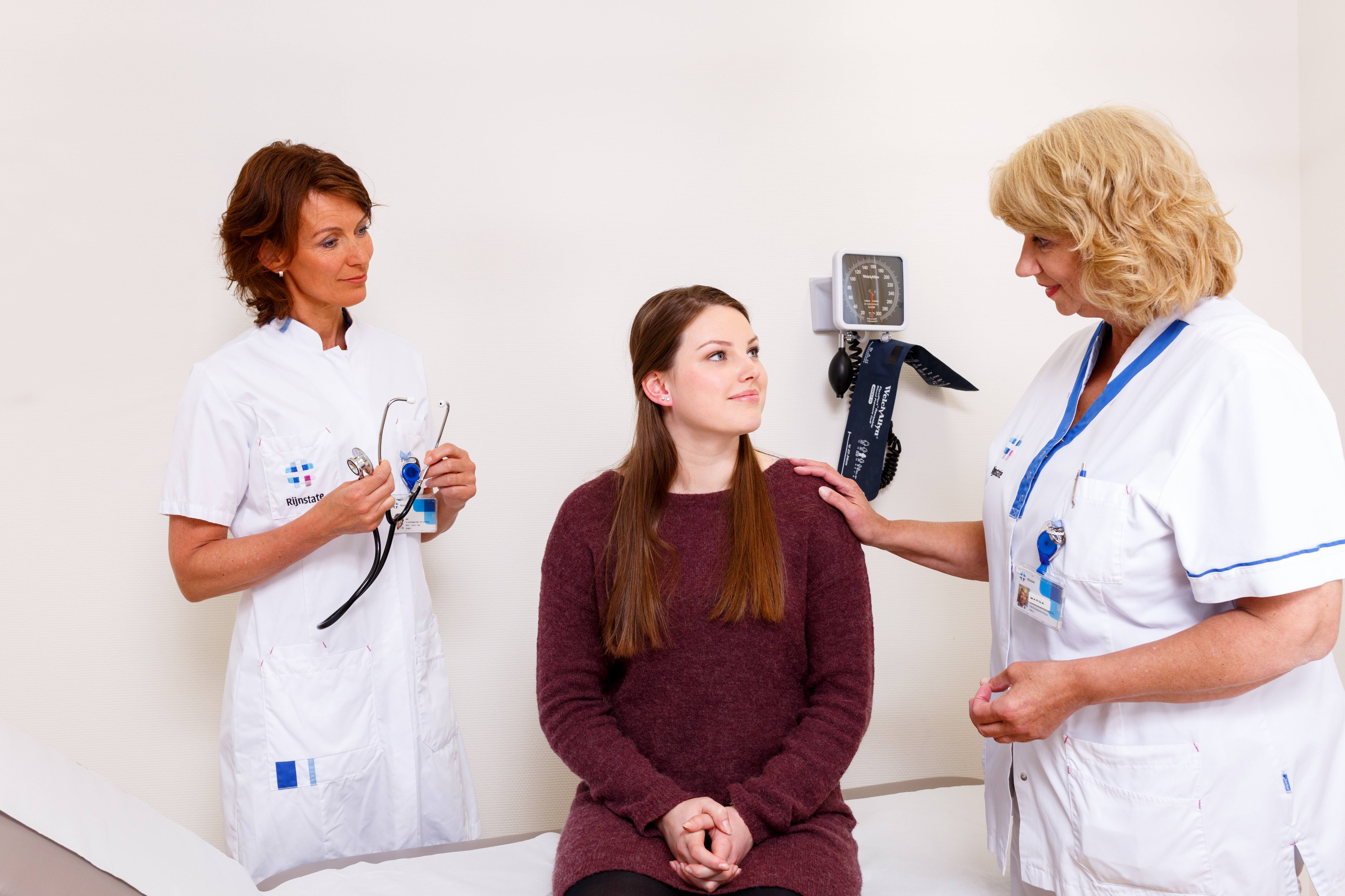 Patiënte met arts en verpleegkundige in een behandelkamer